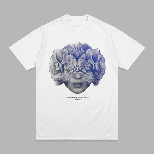 White t-shirt with a surreal illustration of a face with bat wings for hair.