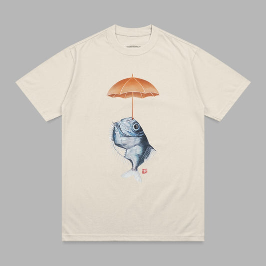 Cream t-shirt with a stylized fish holding an orange umbrella above its head.