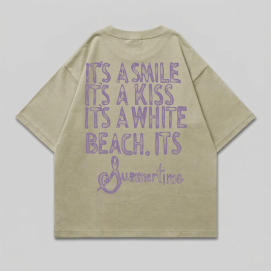 Light tan t-shirt with purple text: "It's a smile, it's a kiss, it's a white beach. Summertime".