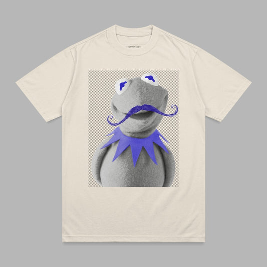 Kermit the Frog with a purple mustache and blue eyes on a cream t-shirt.