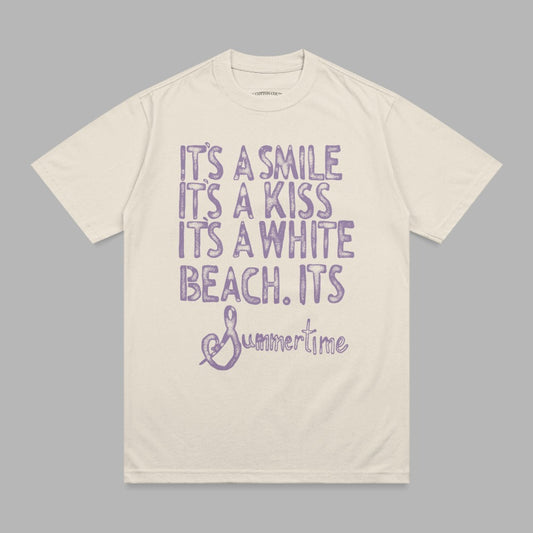 Cream t-shirt with purple distressed text "It's a smile, it's a kiss, it's a white beach, it's Summertime."