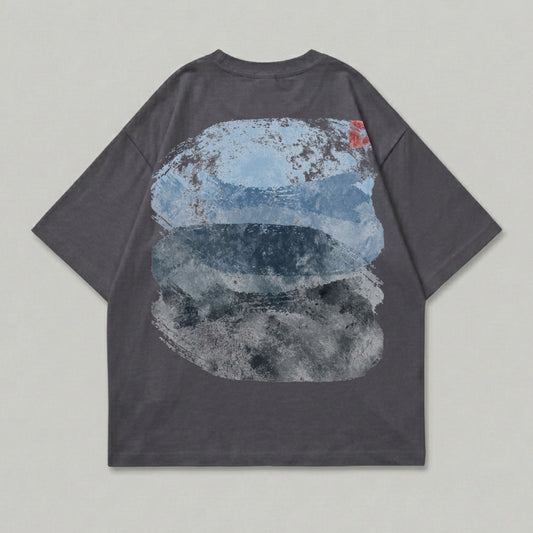 Dark grey t-shirt with abstract blue and grey brushstroke design on back.