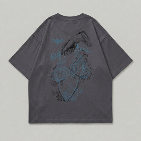 Dark gray t-shirt with dragonfly, hand sprinkling flowers, and "Keep Calm" text.
