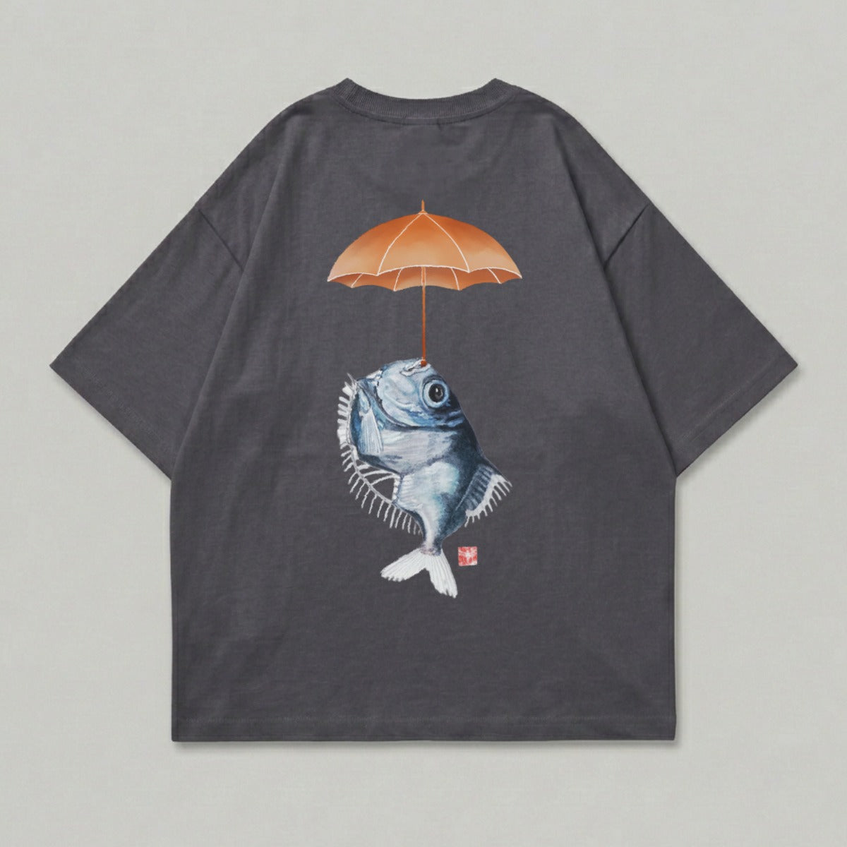 T-shirt with graphic of a fish holding an umbrella over its head.