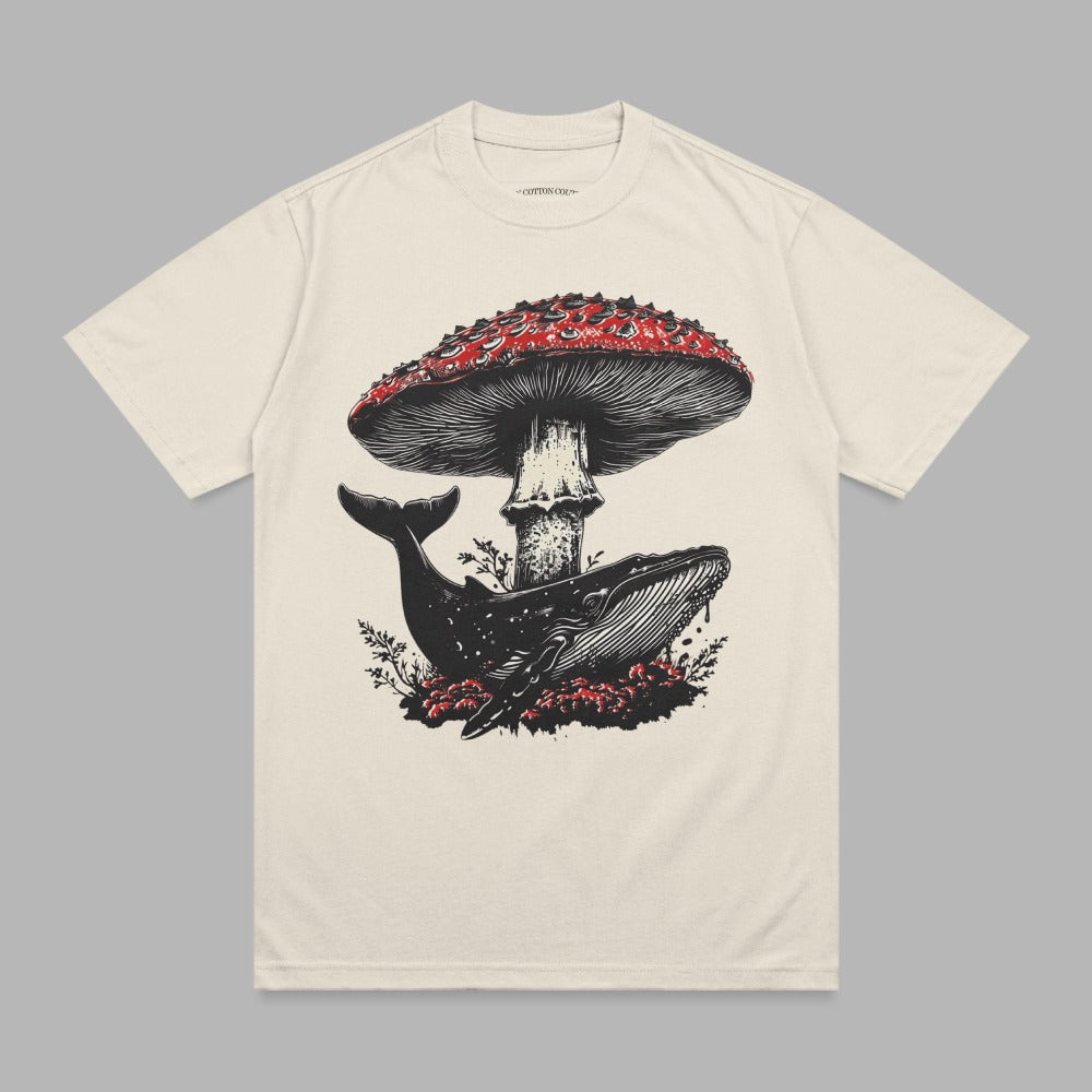 Cream t-shirt with whale under a red mushroom graphic.