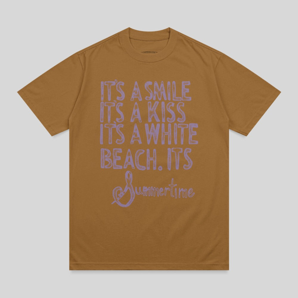 Brown t-shirt with light purple text: "It's a smile, it's a kiss, it's a white beach. It's Summertime."