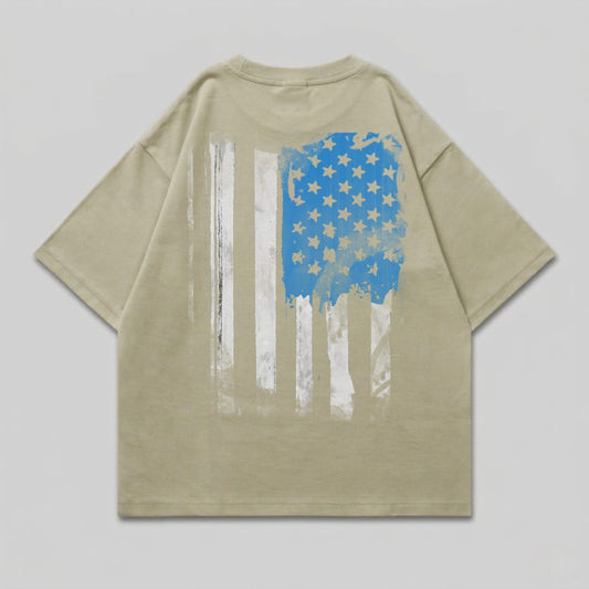 Tan t-shirt with distressed American flag graphic on back.
