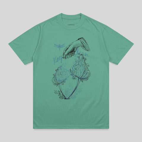 T-shirt with hand reaching for two blue flowers and dragonfly.