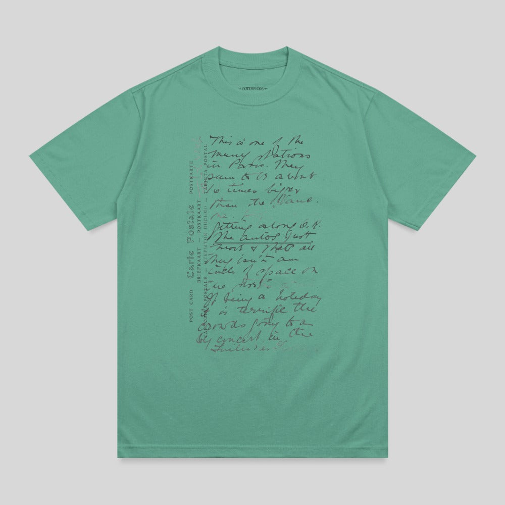 Green t-shirt with handwritten text and "POST CARD" in multiple languages.