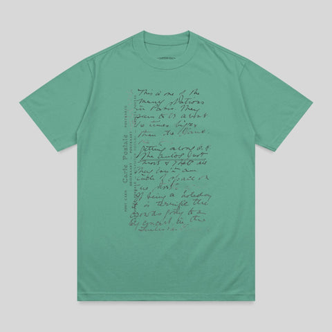Green t-shirt with handwritten text and "POST CARD" in multiple languages.