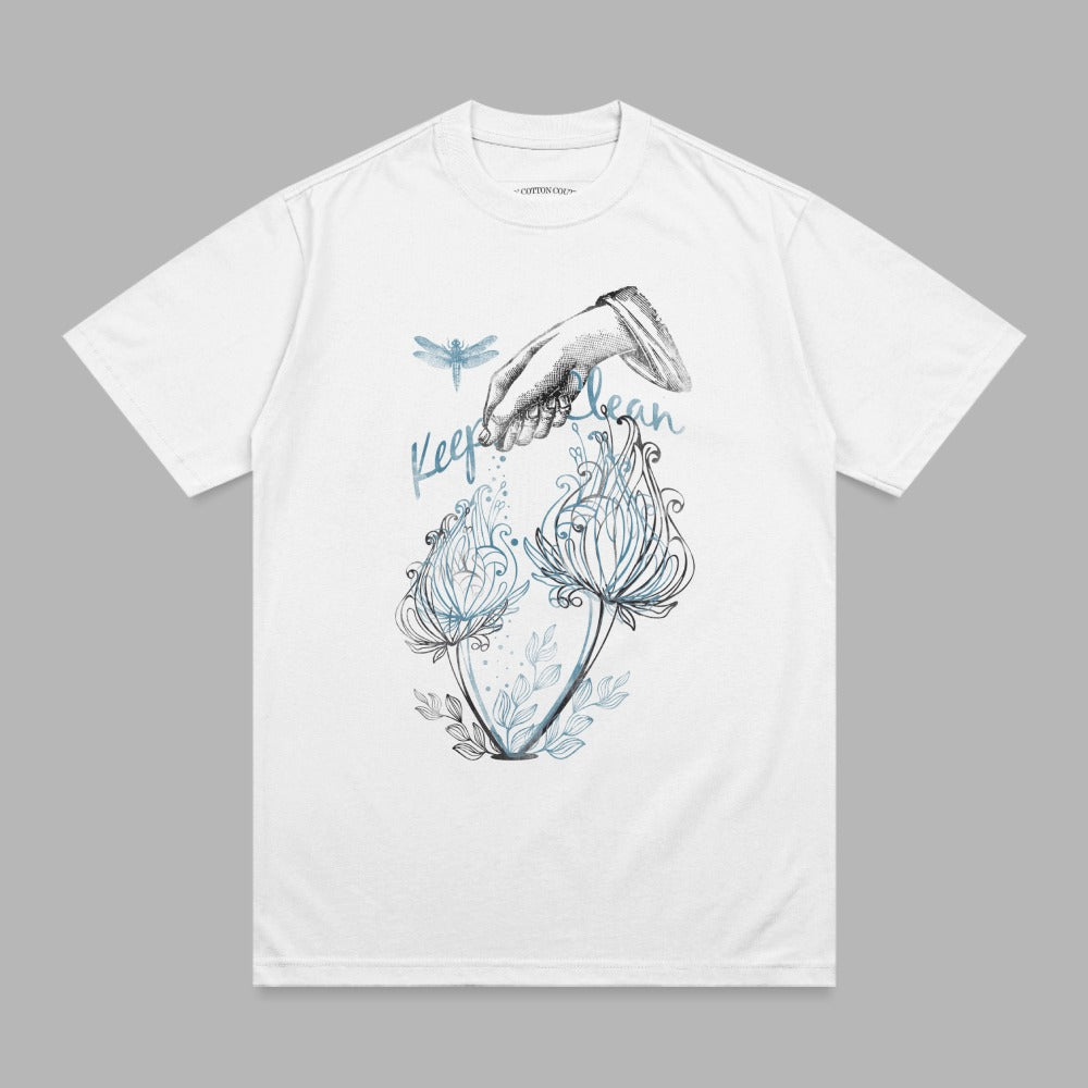 White t-shirt with blue dragonfly and floral illustration, text reads "Keep it clean".
