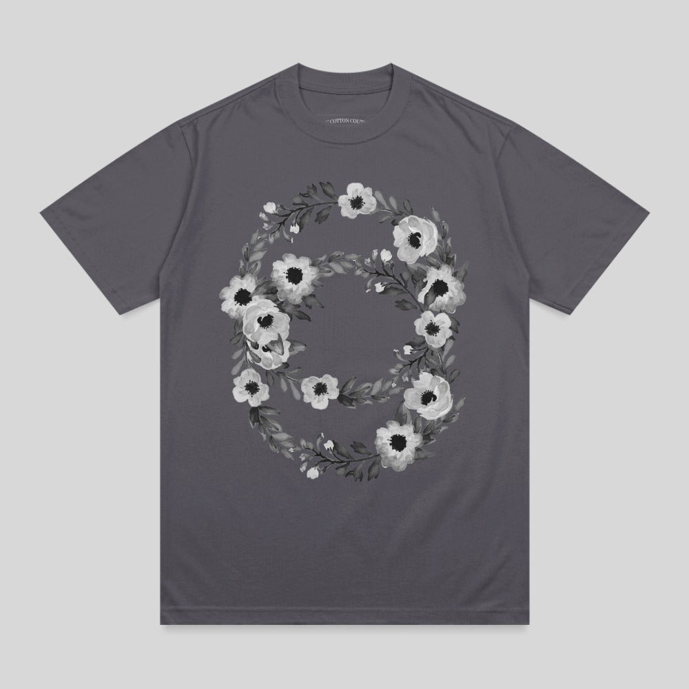 Dark gray t-shirt with a floral wreath design featuring white and gray flowers.