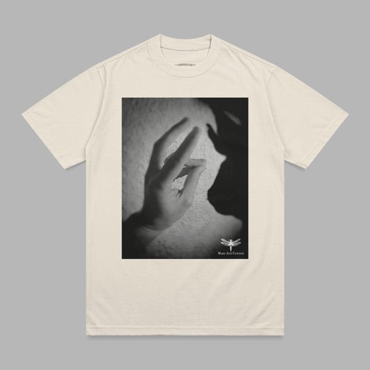 Cream t-shirt with a black and white graphic of hands and shadow.