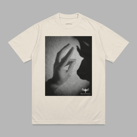 Cream t-shirt with a black and white graphic of hands and shadow.