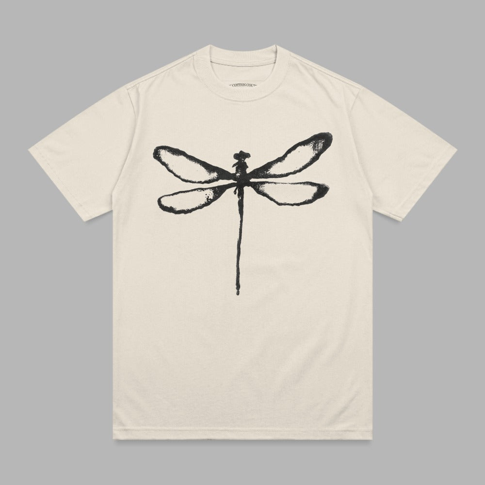 Cream t-shirt with a black dragonfly graphic and small text at the neckline.