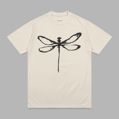 Cream t-shirt with a black dragonfly graphic and small text at the neckline.