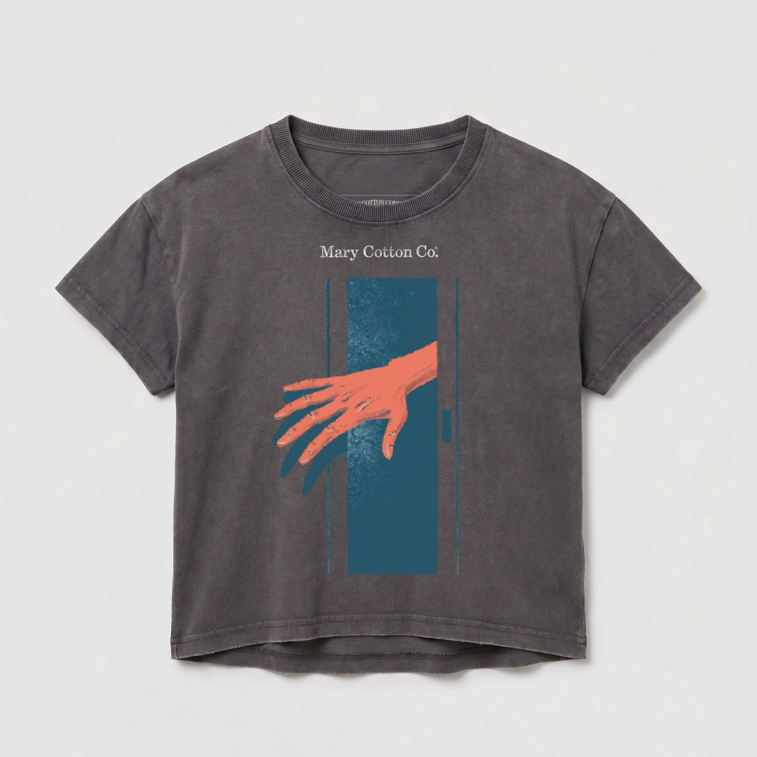 T-shirt with an orange hand reaching through a dark blue doorway.