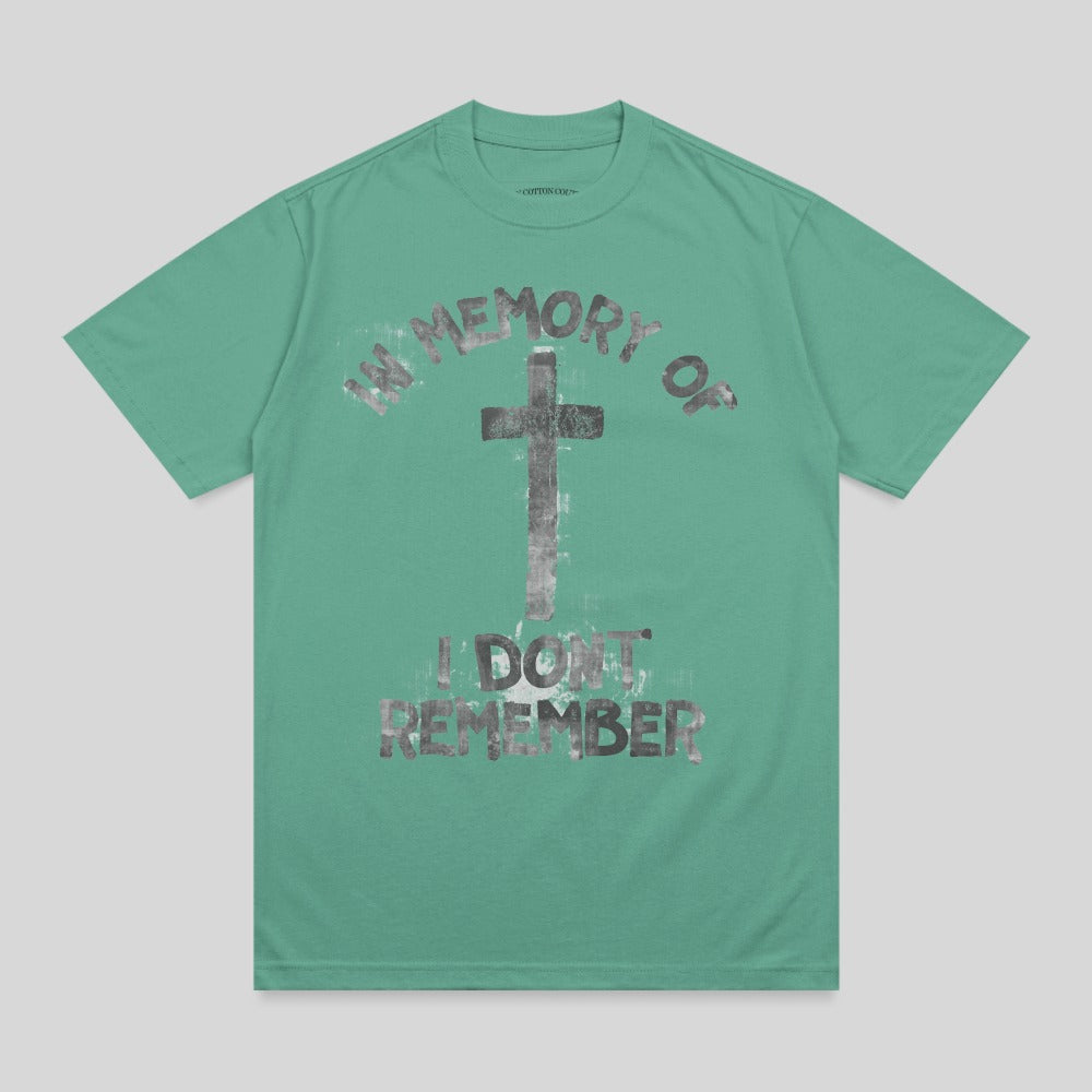 Green t-shirt with graphic print reading "in memory of i don't remember" and a cross.