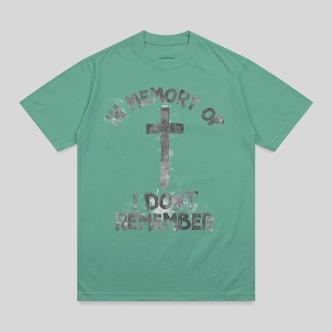 Green t-shirt with graphic print reading "in memory of i don't remember" and a cross.