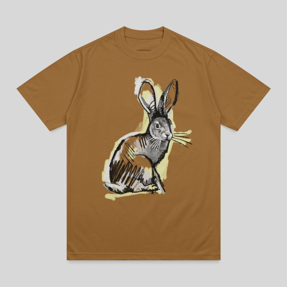 Brown t-shirt with a sketched illustration of a rabbit eating grass.
