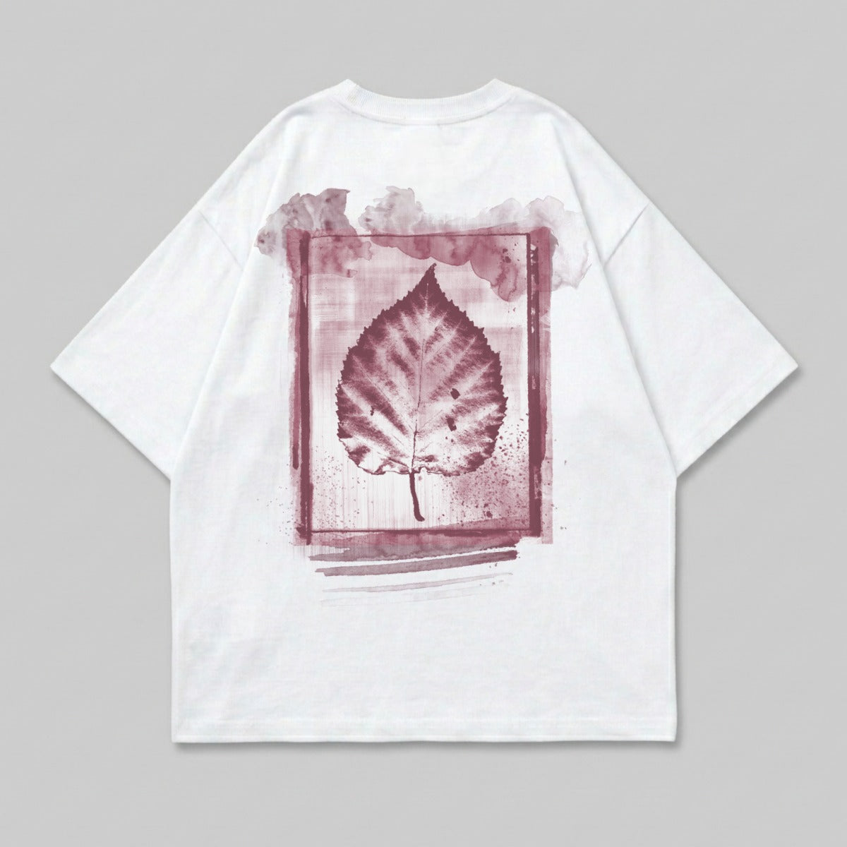 White t-shirt with a reddish-brown leaf print in a watercolor frame.