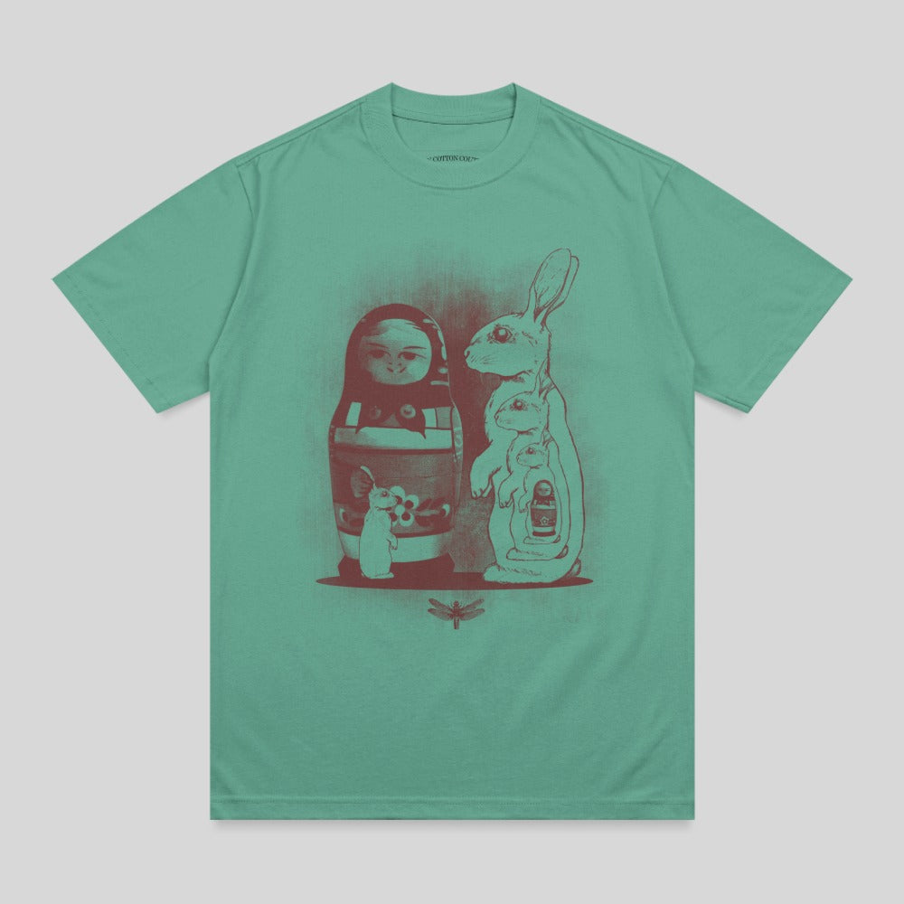 Matryoshka doll with bunnies and a dragonfly, graphic print on teal t-shirt.