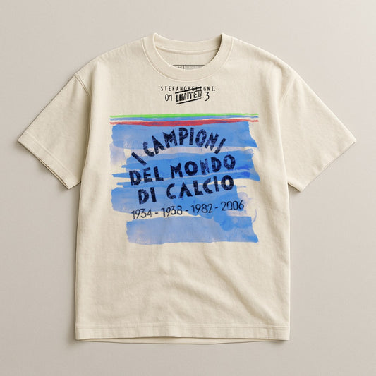 Cream t-shirt with blue and green brushstrokes and "CAMPIONI DEL MONDO DI CALCIO 1934-1938-1982-2006" text.