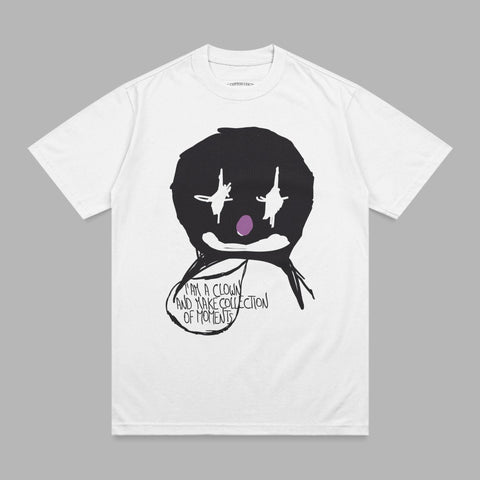 White t-shirt with a black clown face graphic and text bubble.