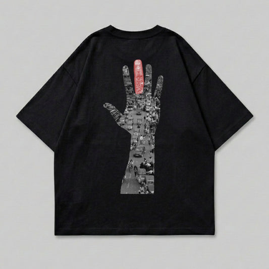 Black t-shirt with graphic of hand outline filled with busy street scene.
