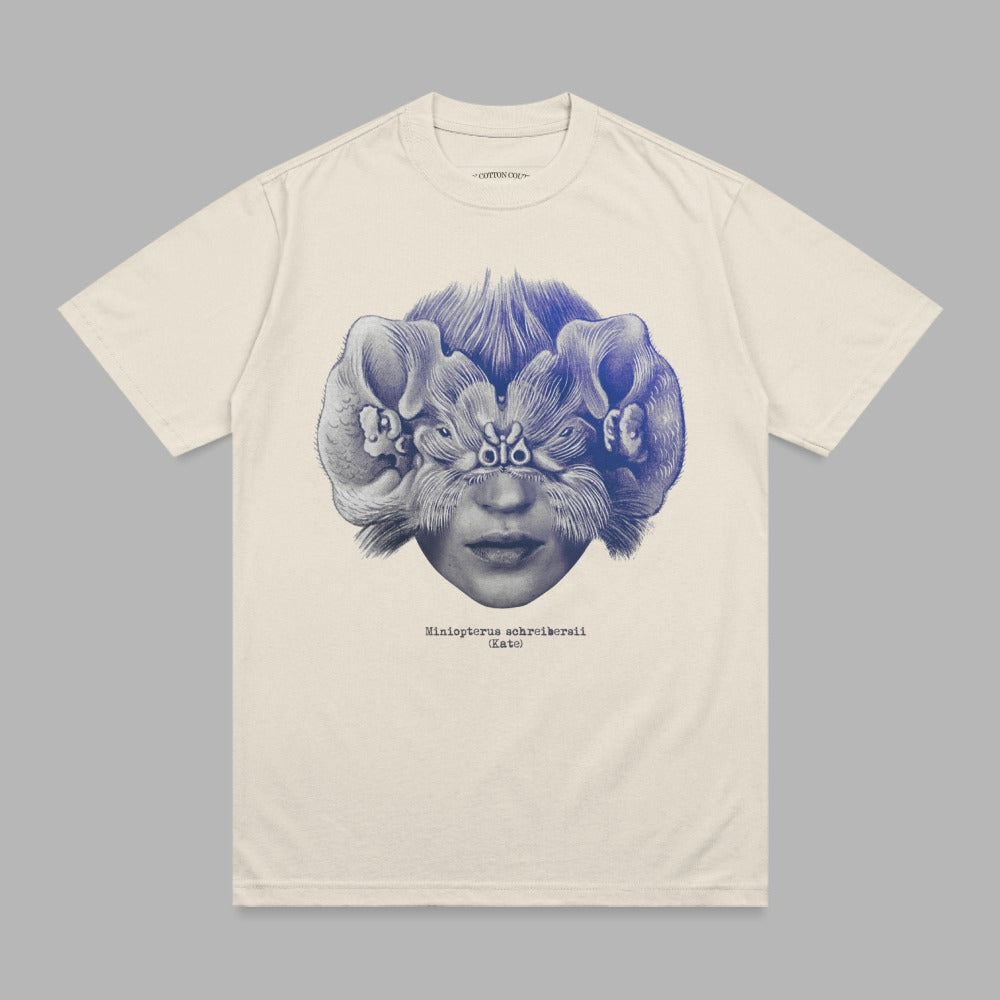 Cream t-shirt with blue surrealist illustration of a face with bats.