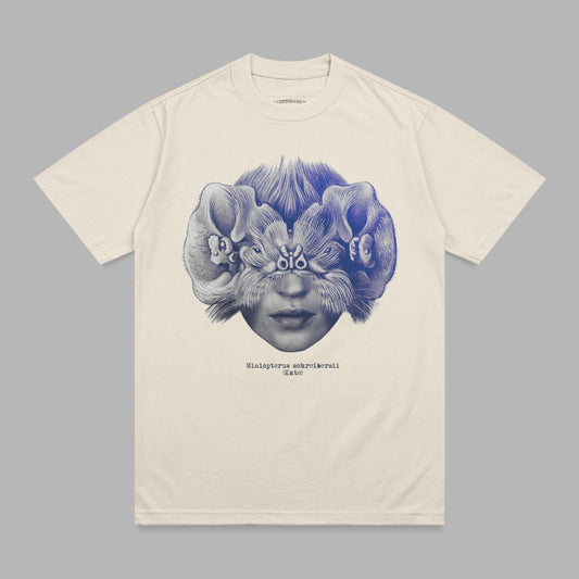Cream t-shirt with blue surrealist illustration of a face with bats.