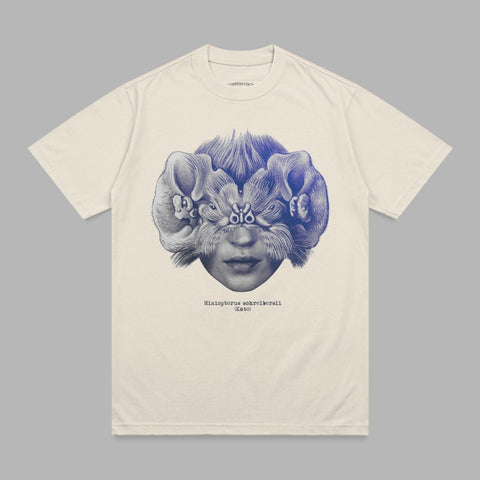 Cream t-shirt with blue surrealist illustration of a face with bats.