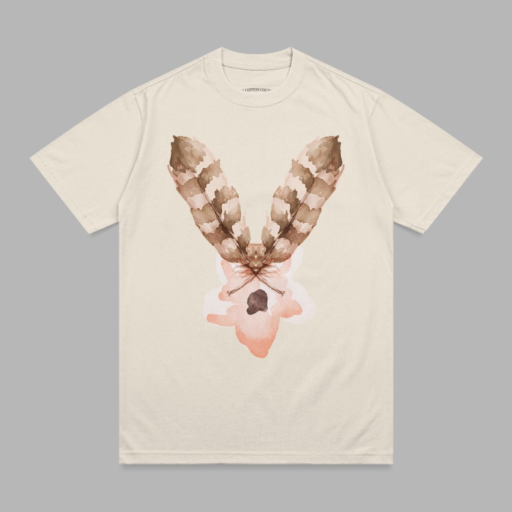 Cream t-shirt with brown feather and abstract pink design.