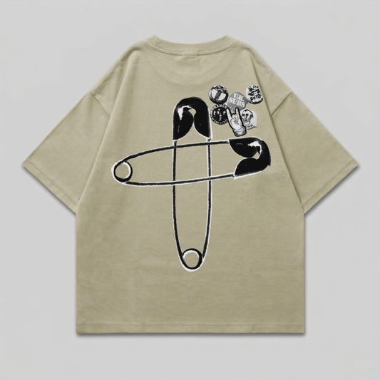 T-shirt with large safety pin graphic and multiple circular patches on the back.