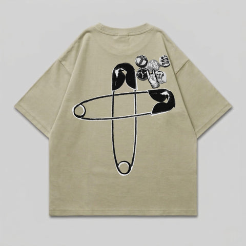 T-shirt with large safety pin graphic and multiple circular patches on the back.