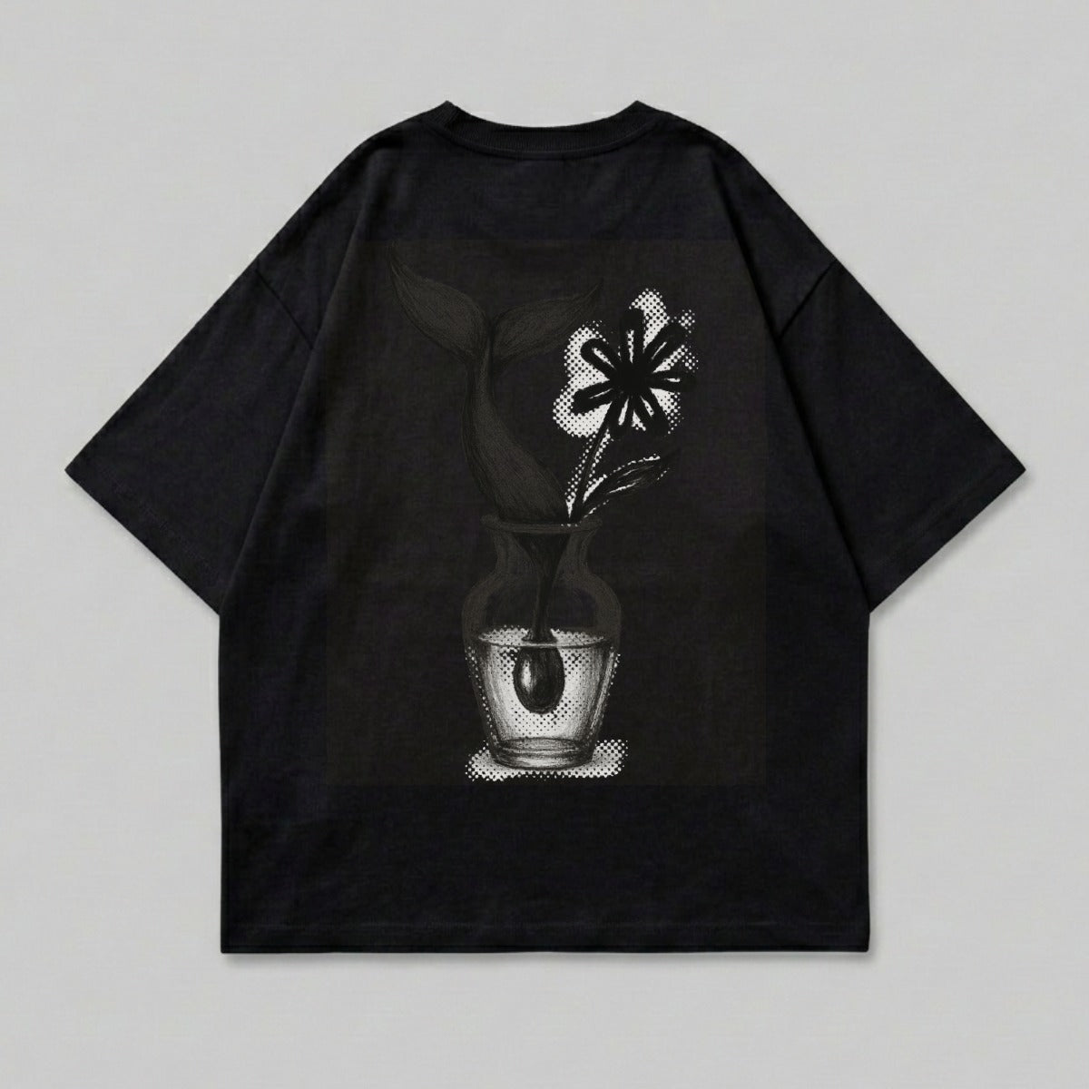 Black t-shirt with graphic of flower in vase on back.
