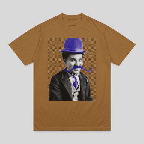 Charlie Chaplin in a bowler hat and purple bowtie, smiling.