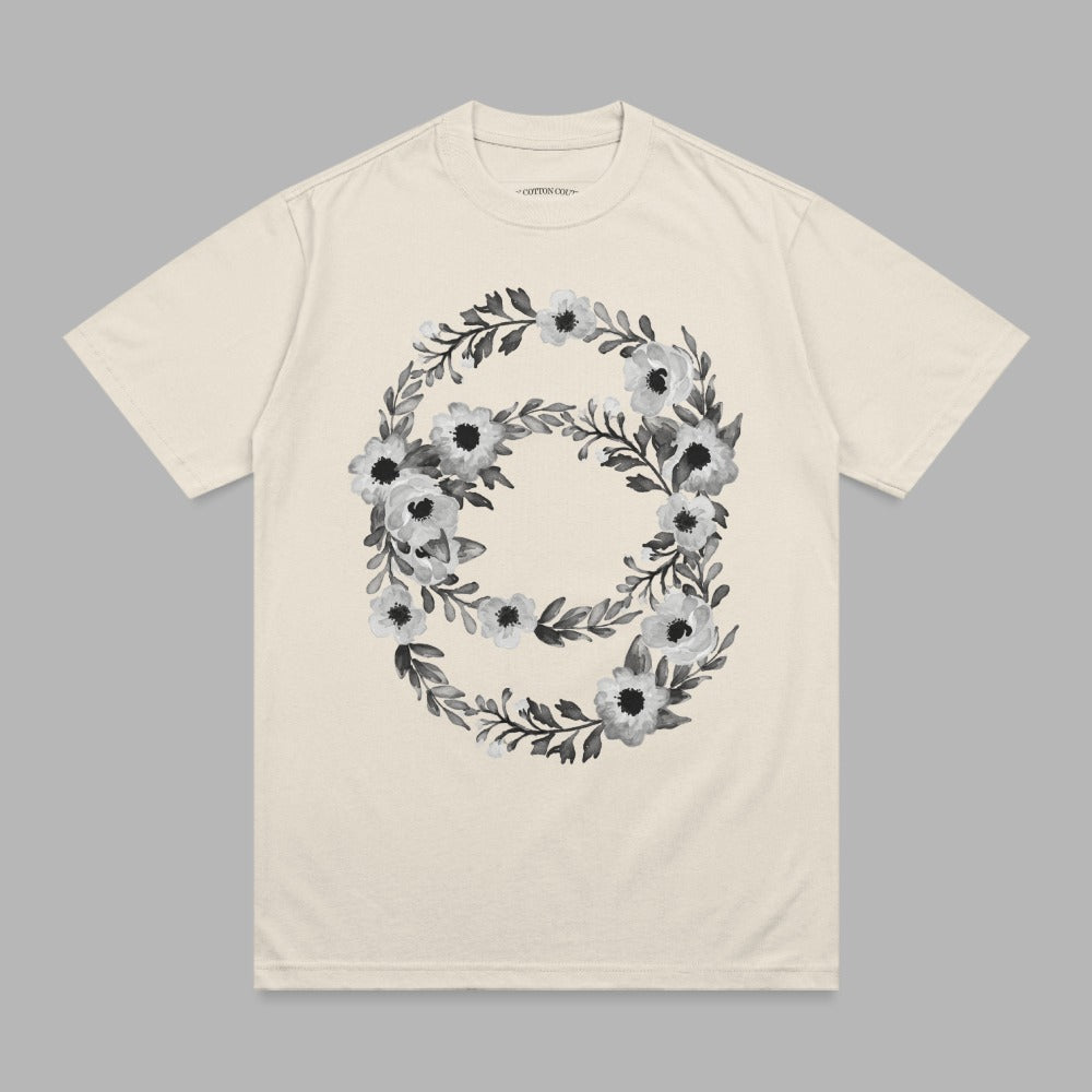 Cream t-shirt with a floral wreath design in black and white.