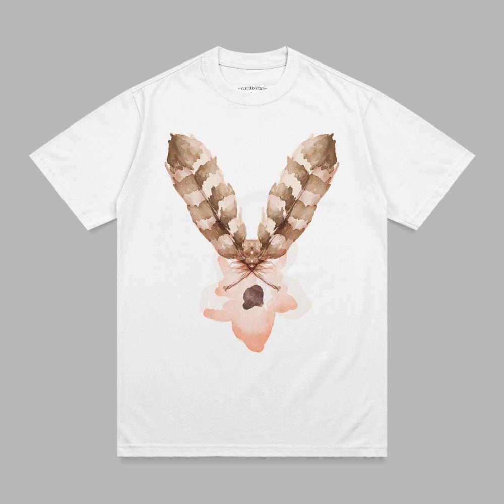 White t-shirt with brown feather graphic and pink watercolor splash.
