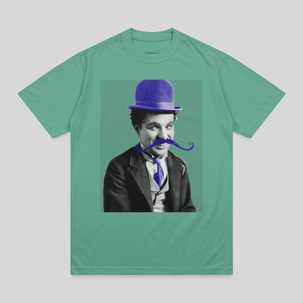 Charlie Chaplin wearing a purple bowler hat and tie on a green t-shirt.