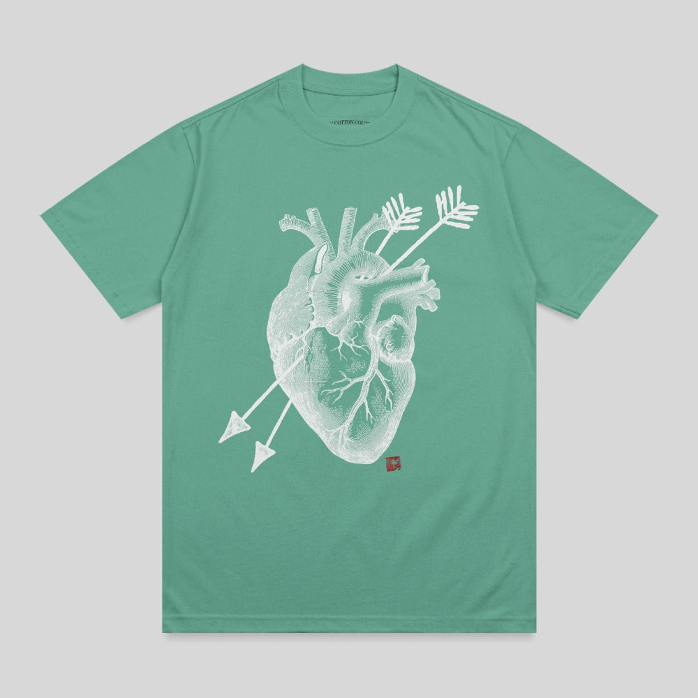 Green t-shirt with a white anatomical heart graphic pierced by two arrows.