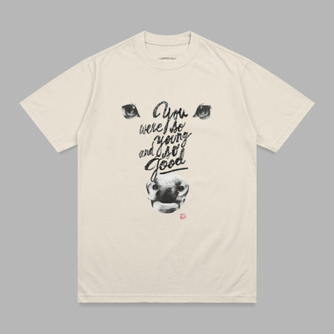 Cream t-shirt with black graphic of a bull's face and "You were so young and I so good" text.
