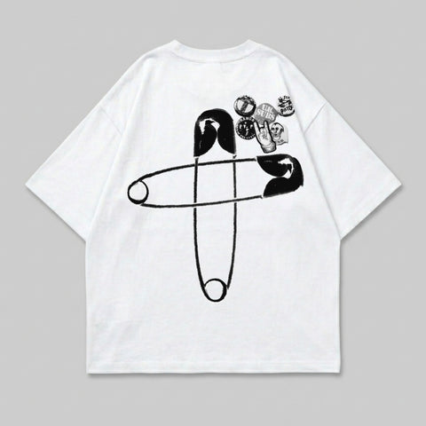 White t-shirt with large safety pin graphic and assorted band pins.
