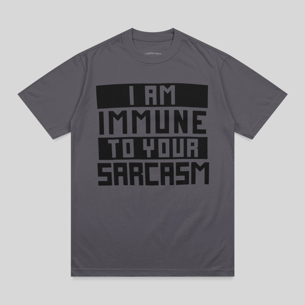Dark gray t-shirt with bold black text "I AM IMMUNE TO YOUR SARCASTIC".