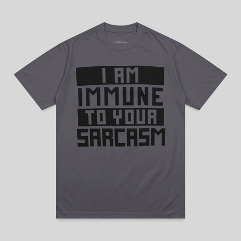 Dark gray t-shirt with bold black text "I AM IMMUNE TO YOUR SARCASTIC".