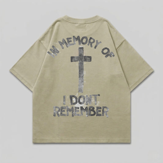 Khaki t-shirt with black cross and "IN MEMORY OF I DON'T REMEMBER" text.