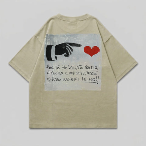 Light tan t-shirt with a black hand pointing to a red heart and Italian text.