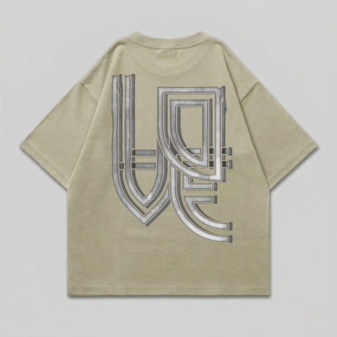 Oversized tan t-shirt with a large, metallic geometric graphic on the back.