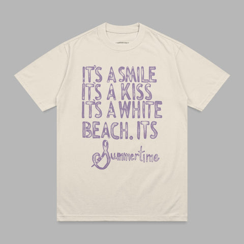 Cream t-shirt with purple distressed text "It's a smile, it's a kiss, it's a white beach, it's Summertime."