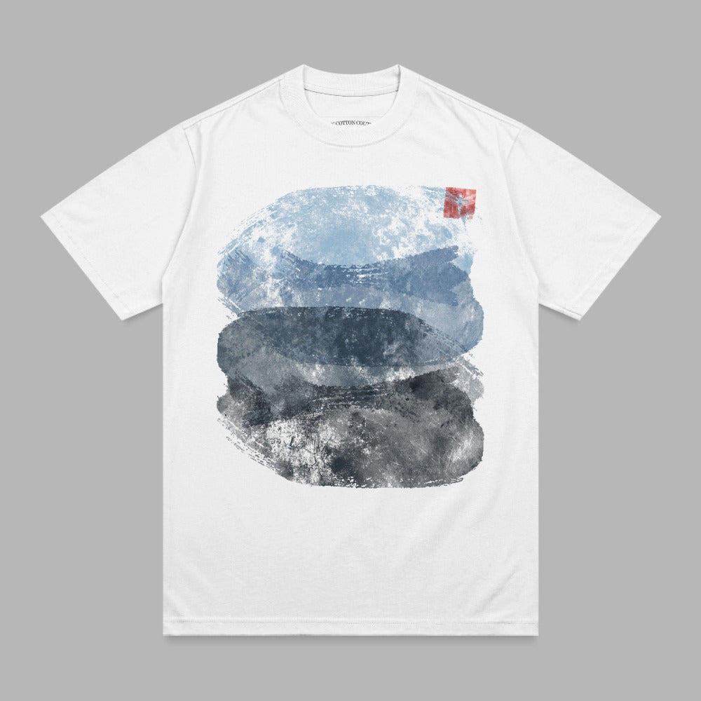 White t-shirt with abstract watercolor brushstrokes in blue, gray, and black.